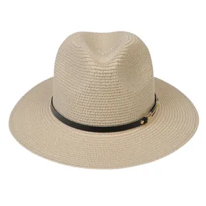 Détail de la texture d'un chapeau de paille avec ruban en cuir noir et boucle dorée