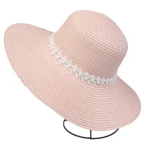 Close-up of pink sun hat featuring white lace trim and elegant pearl bead decoration