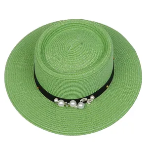 Detailed texture of light green straw hat featuring white pearls and floral decoration