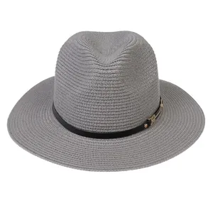 Détail du chapeau Panama gris avec texture tissée, ruban en cuir noir et boucle dorée