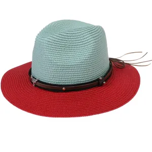 Detail of mint green woven straw hat with red brim and skull pendant leather band