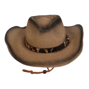 Detalle de sombrero de paja tejida con degradado marrón y cinta de cuero con estampado leopardo