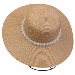 Detail of the woven straw hat with organza floral band and elegant pearl embellishments