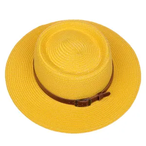 Detail of yellow straw sun hat featuring a brown leather band and metallic buckle