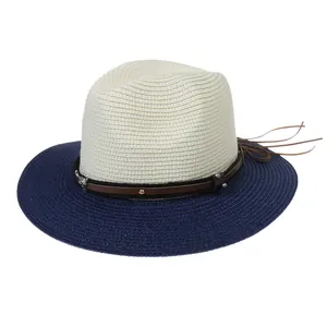 Close-up of dual-tone straw hat featuring leather band with skull metal stud detail