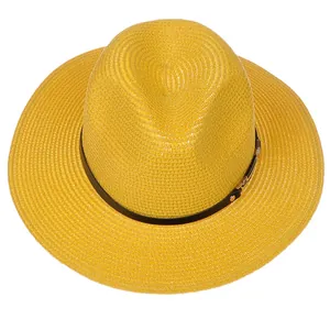Vue détaillée d'un chapeau Panama jaune montrant la paille tressée et le ruban en cuir noir