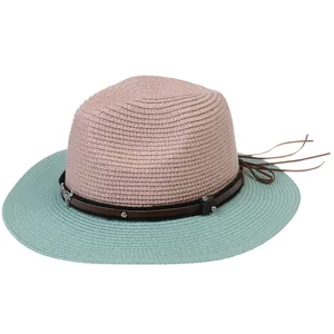 Macro shot of bicolored woven straw hat with mint green brim and metallic ox head decor