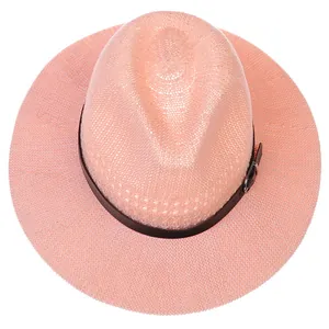 Top view of pink woven straw fedora hat with a black leather belt and silver buckle