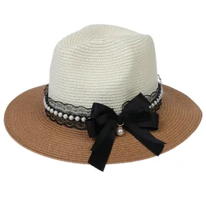 Detail of Panama straw hat featuring black lace, white pearls and a large satin bow