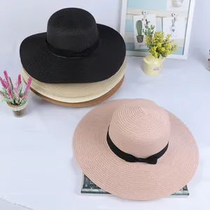 Top view of stackable straw sun hats with black ribbon bows in multiple summer colors