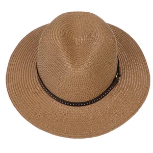Top view of a woven straw Panama hat with a studded leather band on a white background