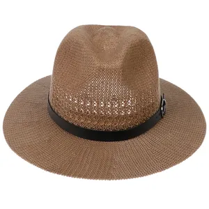 Detail of breathable brown woven straw hat with black leather strap and metal buckle