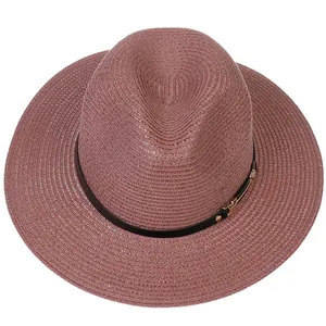 Détail du chapeau Panama tissé mauve avec ruban noir et boucle métallique dorée élégante
