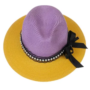 Overhead shot of purple and yellow woven straw fedora with lace and pearl trim