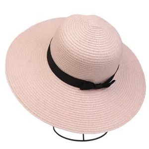 Detailed weave pattern of pink sun hat with black ribbon bow on display stand
