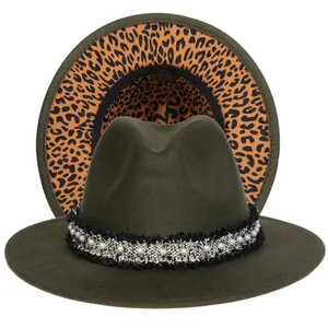 Dettaglio del cappello in feltro verde scuro con perle e fodera leopardata