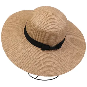 Detailed close-up of woven straw texture and black bow on a wide brim beach sun hat