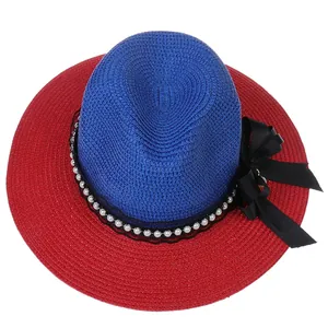 Detail of blue and red straw panama hat with black bow and white pearl band decoration