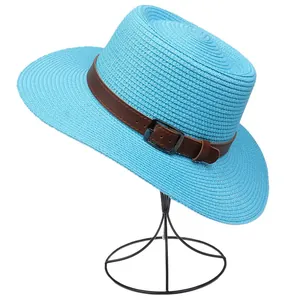 Detail of sky blue woven straw hat featuring a brown leather band and metal buckle