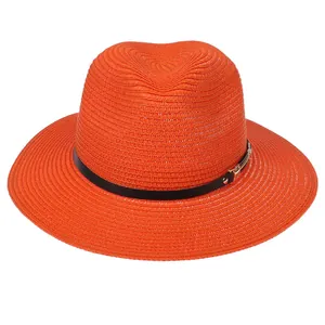 Détail de la texture tressée du chapeau Panama orange avec sangle en cuir et boucle