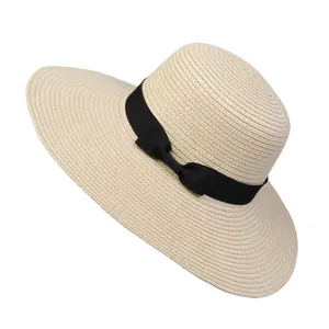 Macro detail of the woven straw texture and black ribbon bow on this summer sun hat