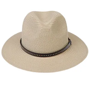 Detail of Panama straw hat featuring a brown leather band with gold and silver metal studs