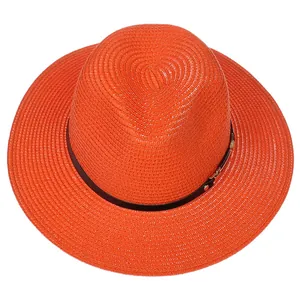 Détail d'un chapeau Panama orange vif avec texture tressée et bande en cuir noir décorative