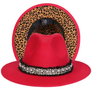 Dettaglio cappello fedora rosso con tesa leopardata e nastro decorato con perle