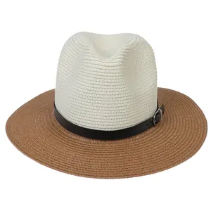 Detail of two-tone foldable Panama straw hat with leather band and metal buckle accent