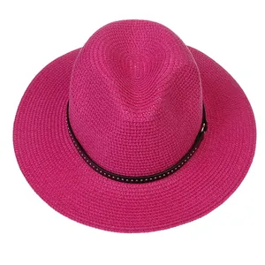 Detail of rose pink straw Fedora with black studded band and gold rivets on crown