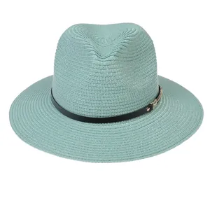 Détail d'un chapeau Panama vert menthe avec tissage fin et ceinture en cuir noir
