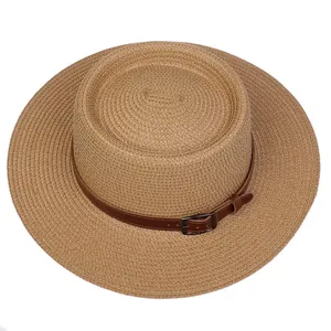 Close-up of woven straw texture with a brown faux leather band and metal buckle detail