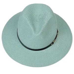 Gros plan d'un chapeau Panama vert menthe avec texture tressée et sangle noire bouclée