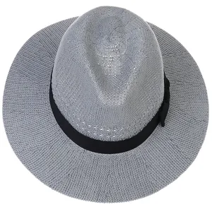 Detail of grey hollow woven sun hat featuring a fine texture and black ribbon bow