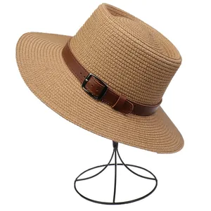 Close-up of woven straw hat featuring a leather band with metal buckle detail