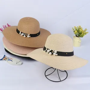 Detail of colorful wide brim straw hats with daisy flowers and pearl decorations