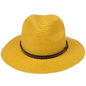 Close-up of yellow straw Panama hat with black studded leather band and woven texture