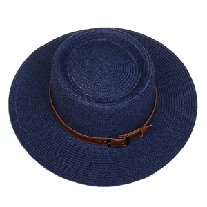 Close-up of a navy blue straw boater hat with a brown leather band and metallic buckle