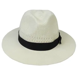 Detail of breathable cream straw fedora hat with fine texture and black ribbon bow
