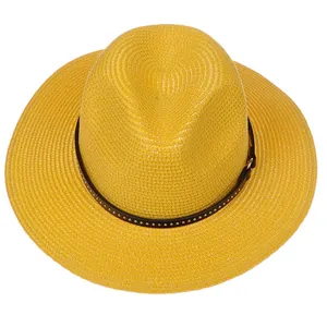 Close-up of yellow Panama straw hat featuring a brown leather band with silver rivets