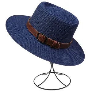 Detail of dark blue straw sun hat featuring a brown leather band and metallic buckle