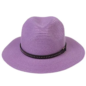 Detail of purple straw Fedora hat featuring woven texture and studded leather band decor