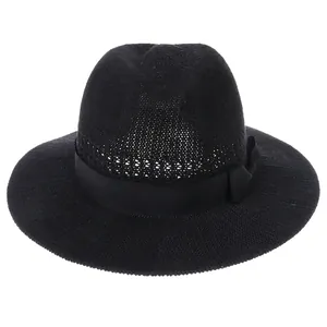 Detailed close-up of black woven straw hat featuring a decorative satin ribbon bow