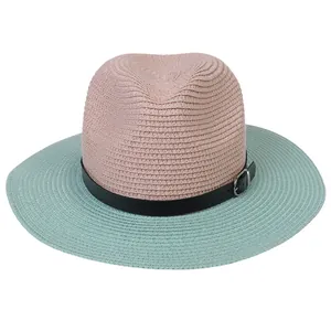 Detail of two-tone straw hat featuring pink crown and mint green brim with leather buckle