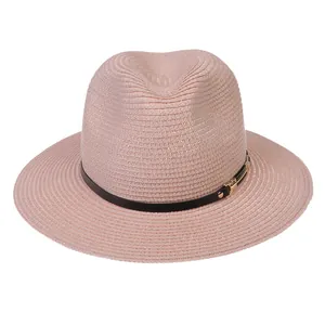 Détail du chapeau Panama rose tissé avec ruban noir et boucle en métal doré chic