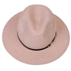 Vue de dessus d'un chapeau Panama rose en paille avec ruban noir et boucle dorée