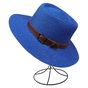 Detail of blue straw sun hat featuring a brown faux leather belt buckle on a minimal stand