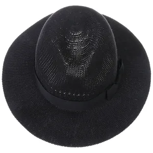 Detail view of a black woven straw sun hat featuring a breathable texture and ribbon bow