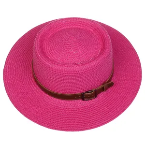 Detail of rose pink straw hat with brown leather band and metallic buckle accent