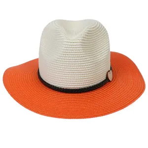 Detail of two-tone woven straw hat with black band and heart wooden pendant decoration
